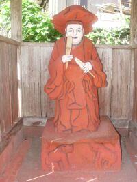 木の祠の中に建っている田の神像の写真