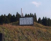 青空の下、案内板が立っている池ノ原一里塚周辺の写真