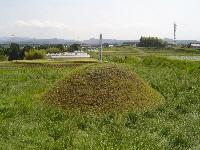 芝生が生い茂る中、こんもりと山なりになっている漆野原一里塚の写真