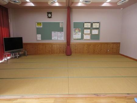 掲示物やテレビが壁際にある和室の写真
