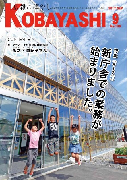 ガラス張りの庁舎の入口で両手をあげてジャンプする子供たちの写真が掲載された広報こばやし9月号の表紙