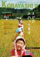 麦畑の中を一列になって歩く子供達と引率者の写真が掲載された広報こばやし10月号の表紙