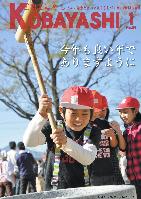 杵を笑顔で振り上げ餅つきする男の子の写真が掲載された広報こばやし1月号の表紙