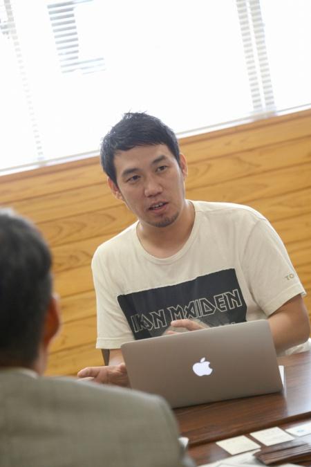 開いたパソコンの前で男性が話している、事前打ち合わせの写真