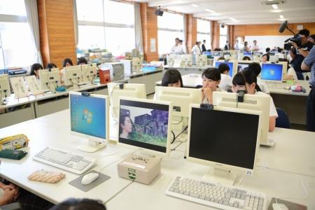 パソコンが並んだ教室で、熱中してモニターを見ている女子生徒たちの写真