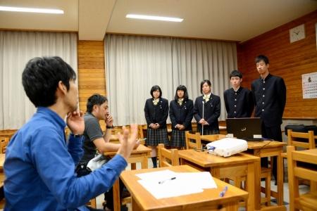 座って話している男性と、並んで話を聞いている生徒たちの写真