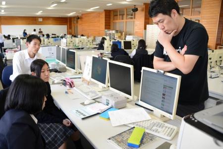 顎に手を当てて何か考えている男性と、パソコンの前に並んで座っている生徒たちの写真