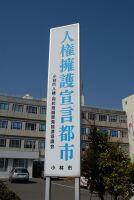A photo of a large sign that says "Human Rights Declaration City" standing against a building