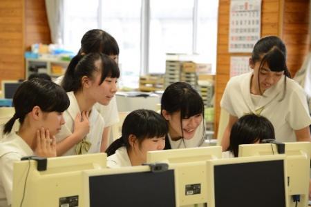 女子生徒7名がパソコンのモニターを見つめている写真