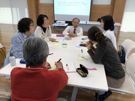 筆記用具を持ちテーブルを囲んで市民講座を行う人たちの写真