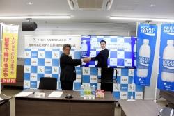 モニター越しに市長と大塚製薬株式会社の代表が握手を結んでいる写真