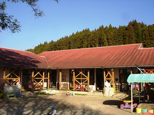 山中にある赤茶色をした屋根の建物の写真