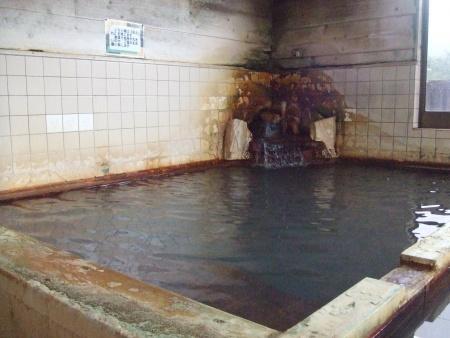 温泉が並々と注がれた「コスモス温泉」の浴槽の写真