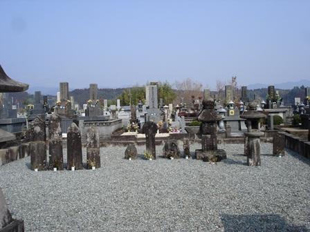 青空と砂利の敷かれた敷地、お墓が映っている写真