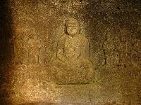 洞窟内で照明に照らされ浮かび上がる東麓石窟仏の写真