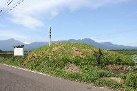 道路のすぐ近くにこんもりと山なりになっている大萩古墳の写真