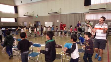 ホールで児童たちが円になって椅子取りゲームをしている写真