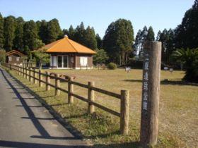木の柱に二原遺跡公園と書かれた入り口と芝生が広がる公園内の写真