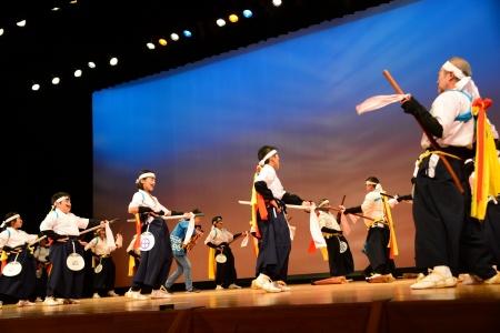 武士の服装に身を包んだ演者たちが模造刀を携えて踊る写真