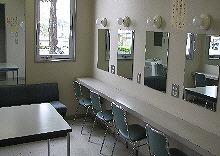 小林市文化会館小ホール内の壁付鏡やソファーなどが完備された控室1の様子を撮影した写真