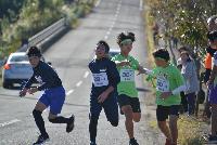 こばやし駅伝競走大会において、2チームほぼ同時にタスキリレーが行われる様子の写真