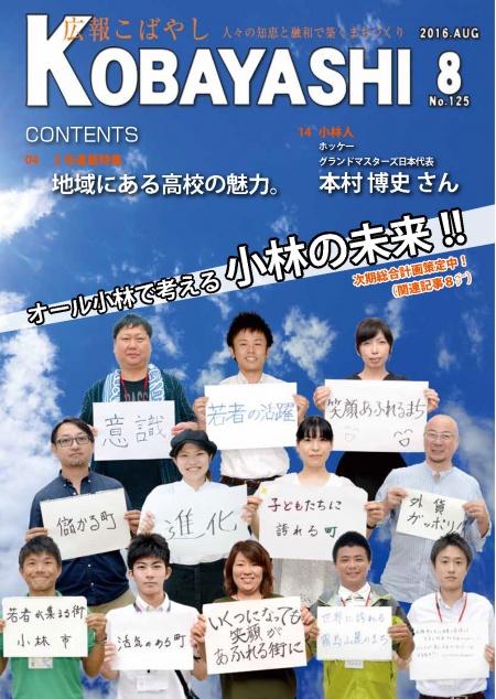 各々で考えた小林市のスローガンを書いた紙を胸の前に掲げた男女12人の写真が掲載された広報こばやし8月号の表紙
