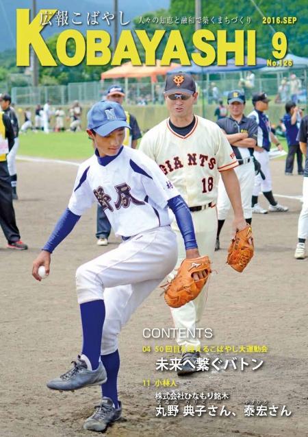 運動場で投球練習をするユニフォーム姿の青年とそれを見守る巨人のユニフォームを着た男性の写真が掲載された広報こばやし9月号の表紙