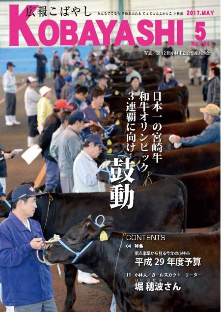 黒毛の牛を撫でたり毛並みを整えてあげている酪農スタッフたちの写真が掲載された広報こばやし5月号の表紙