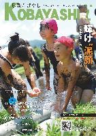 水着姿で水田に入り、泥だらけになりながらも笑顔を見せる子供達の写真が掲載された広報こばやし7月号の表紙