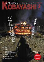 燃えるキャンプファイヤーの火を囲み、長い棒の先に付けた餅を焼いている人達の写真が掲載された広報こばやし2月号の表紙