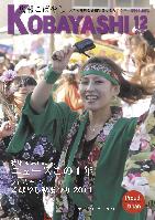 カラフルなお祭りの衣装を着た女性が躍っている写真が掲載された広報こばやし12月号の表紙