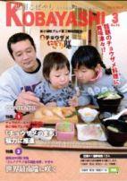 お父さんと二人の子供がチョウザメにぎり膳を食べようとしている写真が掲載された広報こばやし3月号の表紙