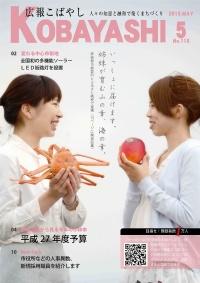 一人は蟹を、もう一人はりんごをそれぞれ手に持ち笑顔で向かい合っている女性二人の写真が掲載された広報こばやし5月号の表紙