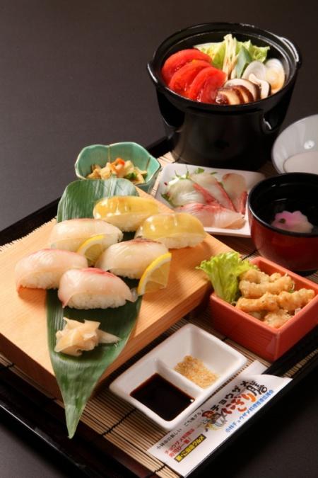鍋物や小鉢、天ぷら、にぎりが並んだチョウザメ握り膳の写真