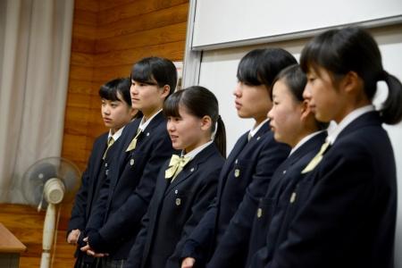 女子生徒たちが並んで立っている様子を横から撮影した、プレゼンテーションの写真