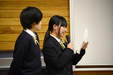 紙を見ながら話している女子生徒と、その横に一人の女子生徒が立っている写真
