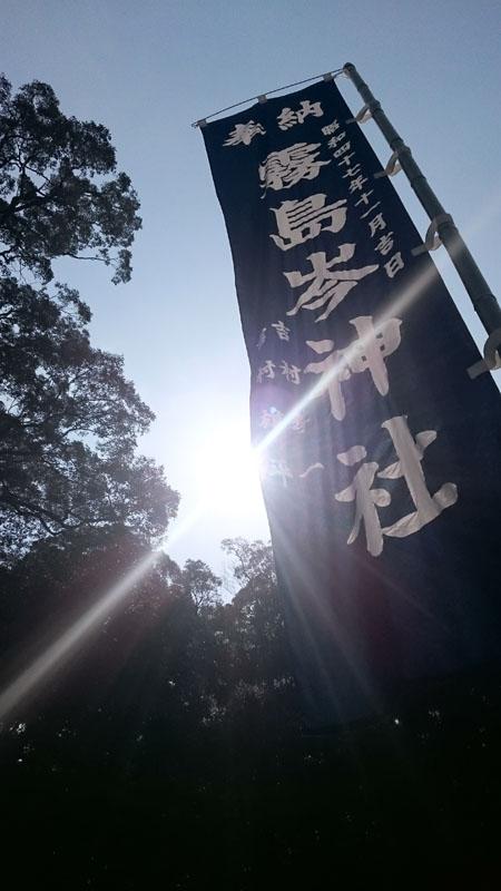 眩い太陽光と霧島岑神社ののぼりを映した写真